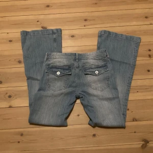 Ljusblå bootcut jeans - Säljer ett par snygga blå jeansbyxor från hm barnsavdelning i storlek 164. De har fickor med knappar på baksidan. Använda en gång så de är som nya. Kontakta mig privat vid intresse eller frågor 