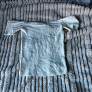 Vit ribbad offshoulder topp från H&M Divided - Säljer en superfin vit ribbad offshoulder topp från H&M Divided i storlek XS. Perfekt för sommardagar eller en utekväll. Toppen har en tight passform och är i mycket bra skick. Passar både till jeans och kjol för en stilren look.