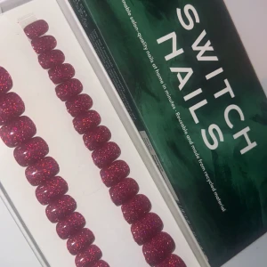 Glittriga röda lösnaglar från Switch Nails - Snygga glittriga röda lösnaglar från Switch Nails. Perfekta för en festlig look! De är återanvändbara och gjorda av återvunnet material. Lätta att applicera hemma för en salongskvalitet på nolltid. 💅✨