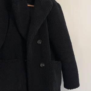 Svart teddykappa - Fin svart teddykappa från newlook köpt på asos, storlek small. Väldigt bra skick & varm & mysig på vintern.