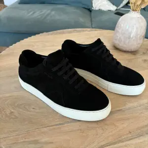 Snygga svarta sneakers i mocka med vit sula. Perfekta för en stilren look, oavsett om du ska på stan eller hänga med vänner. De har snörning och en bekväm passform. Ett måste i garderoben för alla sneakerheads!