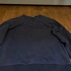 Mörkblå sweatshirt från Ralph Lauren - Säljer en snygg mörkblå sweatshirt från Ralph Lauren. Den har en diskret logga på bröstet och är perfekt för en avslappnad stil. Tröjan är i bra skick och passar perfekt för både höst och vår. Skön och stilren design som funkar till det mesta!