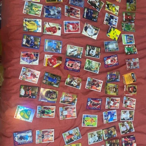 Fotbollsskort - En samling av fotbollskort med olika spelare i färgglada designer. Kortens bakgrunder varierar i färg och stil, med spelare i olika fotbollskläder. Perfekt för samlare eller fotbollsfans som vill utöka sin kollektion. Pris kan diskuteras vid snabb köp