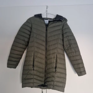 Grön dunjacka från McKinley - Säljer en snygg och varm grön dunjacka från McKinley i storlek 40. Jackan har en dragkedja framtill och en praktisk huva. Perfekt för kalla höst- och vinterdagar. Den är i mycket bra skick och redo för nya äventyr! 🍂❄️