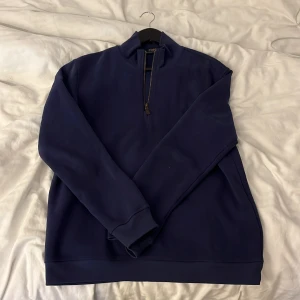 Mörkblå tröja med dragkedja - Säljer en stilren mörkblå tröja med dragkedja i mycket bra skick. Perfekt för höst och vinter, med långa ärmar och en bekväm passform. Tröjan är enkel men snygg och passar till det mesta. Perfekt för både vardag och lite mer avslappnade tillfällen.