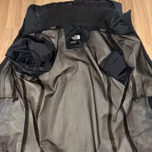 Säljer en svart vindjacka från The North Face i storlek S. Jackan har en praktisk dragkedja och är perfekt för blåsiga dagar. Den är i mycket bra skick och har en stilren design som passar till det mesta. Perfekt för höst och vår! Priset kan diskuteras vid snabb affär 