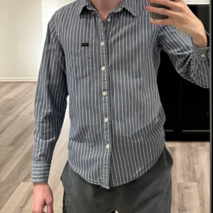 Lee skjorta - Säljer min killes Lee skjorta inköpt för några år sedan.  I mycket fint skick. Han använder sina kläder sparsamt och med välvård.  Unisex Strl S. Han är 190. På mig sitter den mer som en M.