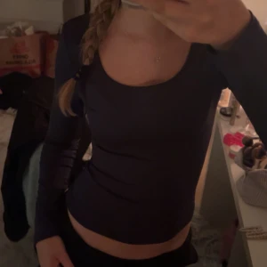 Marinblå långärmad topp - Säljer en snygg marinblå långärmad topp i tight passform. Perfekt för både vardag och fest. Toppen är enkel och stilren, vilket gör den lätt att matcha med olika outfits. Nästan aldrig använd. 