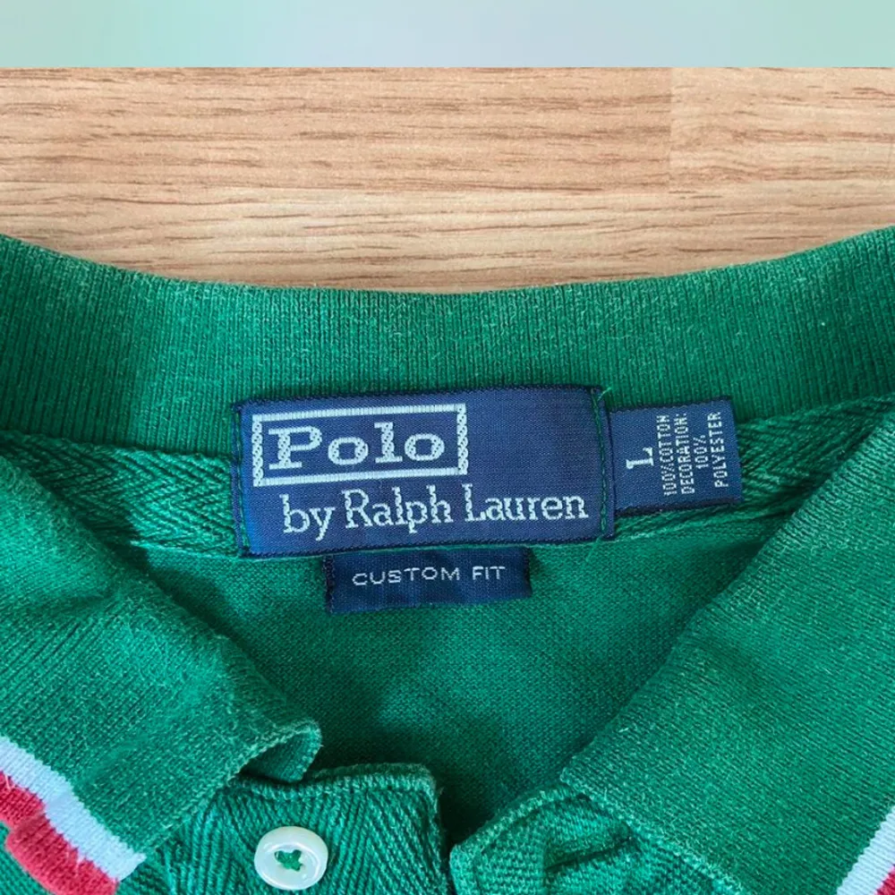 Säljer en snygg grön pikétröja från Ralph Lauren med texten 'ITALY' och nummer 10 på både fram- och baksidan. Tröjan har vita och röda detaljer på kragen och ärmarna. Perfekt för dig som älskar sportig stil och vill sticka ut!. Tröjor & Koftor.