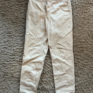 Filippa k chinos 48 - Beige chinos med resår i midjan och dragsko. Byxorna har två fickor framtill och två fickor baktill och  är i en rak modell.  Storlek 48  Hälsningar//  Ludvig 