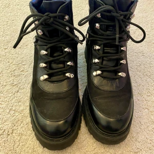 Svarta kängor i skinn - Säljer ett par robusta svarta kängor i skinn, från &Other Stories. De har snörning och en rejäl sula för bra grepp. Perfekta för höst- och vinterväder. Använda ett fåtal gånger. 