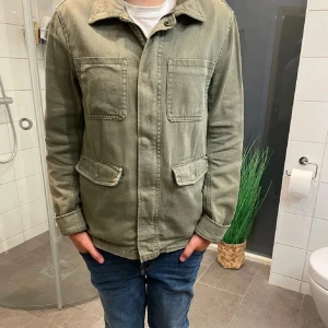 Olivgrön overshirt från H&M - Säljer en olivgrön jacka från H&M i bra skick. Den passar perfekt på mig och jag är 165 cm lång. Den har en klassisk design med två bröstfickor och två fickor nedtill. Perfekt för höst och vår, med en normal passform och långa ärmar. Jackan har en stilren look. Perfekt för vardagsbruk! Skriv för fler bilder eller funderingar😀✍️
