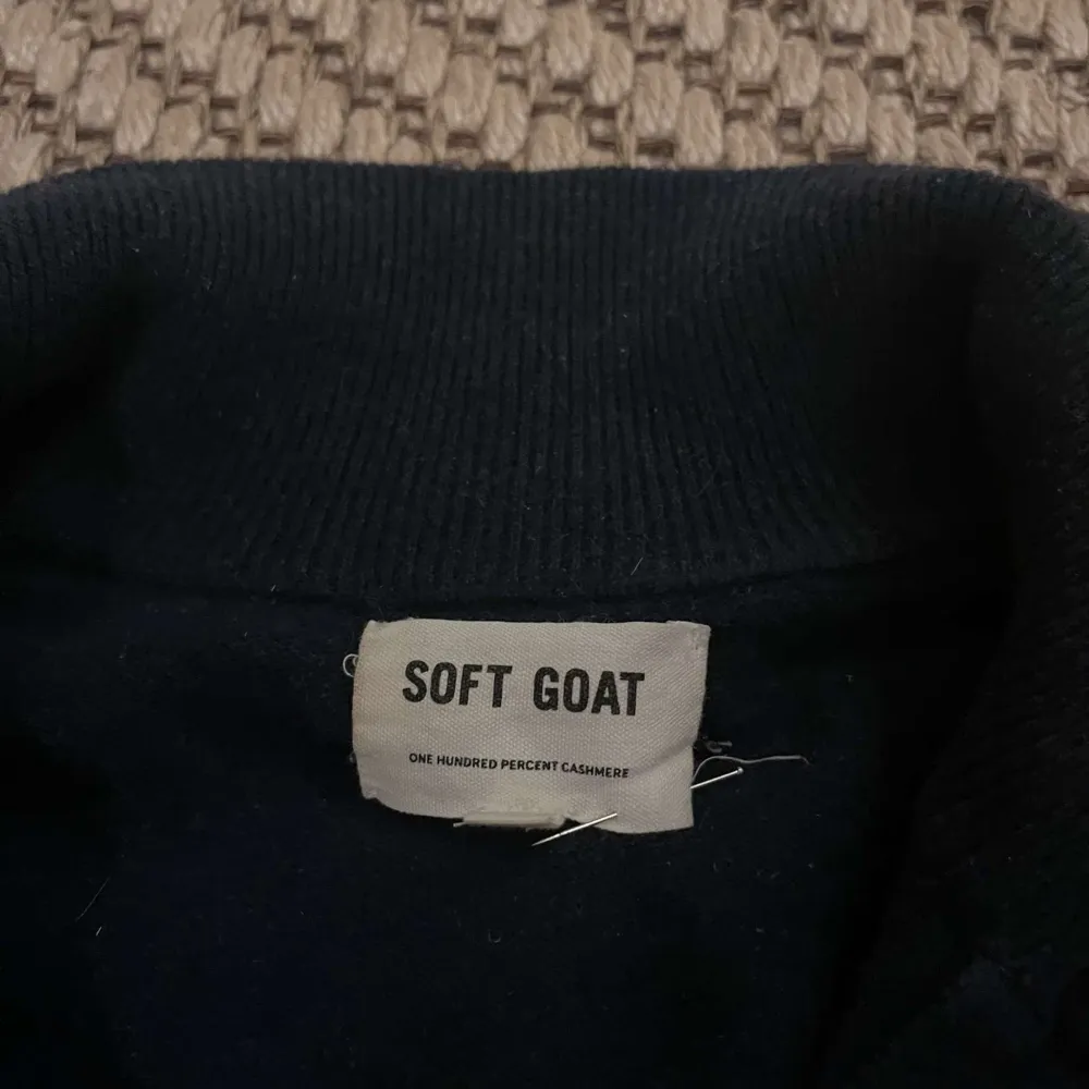 Säljer en elegant mörkblå 100% kashmirtröja från Soft Goat. Den har en dragkedja framtill och långa ärmar, perfekt för kyliga dagar. Tröjan är i mycket bra skick och passar både till vardags och fest. Supermjuk och bekväm! Storlek S. Lagning på armbågen! Skriv vid fler frågor 🐐❄️🪐. Tröjor & Koftor.