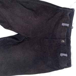 Svarta ridbyxor från Horse Energy - Säljer ett par svarta ridbyxor från Horse Energy. De är i bra skick och har förstärkningar i grått vid knäna för extra hållbarhet. Perfekta för ridning och har en bekväm passform. Passar bra för både träning och tävling.