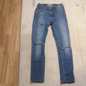 Blå jeans från Acne - Säljer ett par snygga blå jeans från Acne i bra skick. De har en klassisk femficksdesign och slitna detaljer för en trendig look. 