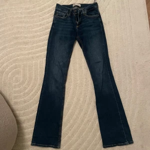 Mörkblå jeans från Zara - Säljer ett par snygga mörkblå jeans från Zara i storlek EUR 34. De är utsvänga  passform. Jeansen är i mycket bra skick och har en bekväm midwaist. Perfekta för höst och vår!