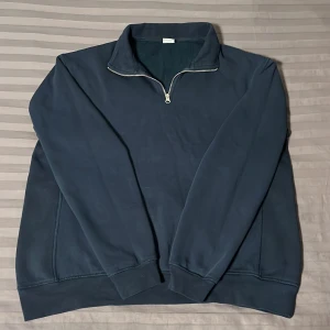 Mörkblå tröja med dragkedja från Zara - Säljer en mörkblå quarter zip tröja från Zara i mycket bra skick. Den har en halv dragkedja framtill och är perfekt för kyliga dagar. Tröjan är gjord i ett mjukt material och har långa ärmar. Passar både till vardags och lite mer avslappnade tillfällen. Pris kan diskuteras!