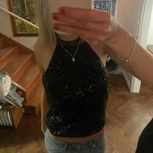 Svart glittrig halterneck topp - Säljer en snygg svart glittrig halterneck topp som inte kommer till användning💞