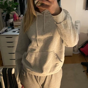 Grå hoodie i mysigt material - Säljer en supermysig grå hoodie i mjukt material. Perfekt för chilliga dagar hemma eller en avslappnad dag ute. Den har en klassisk känguruficka och justerbar huva med snören. Passar perfekt till höst och vinter. 🩶