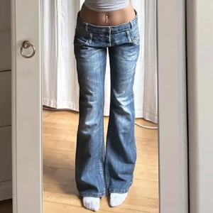 Vintage lågmidjade bootcut jeans - Kommer tyvärr inte till användning, jättefin och det går att ha 2 olika bälten på i samma gång. Midja: 86cm. Innerben: 79cm.