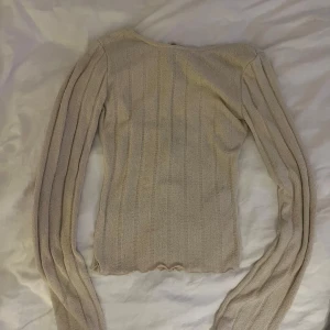 Stickad tröja öppen rygg - Beige stickad tröja med öppen rygg från Gina Tricot i storlek XS. Aldrig använd lappar kvar.