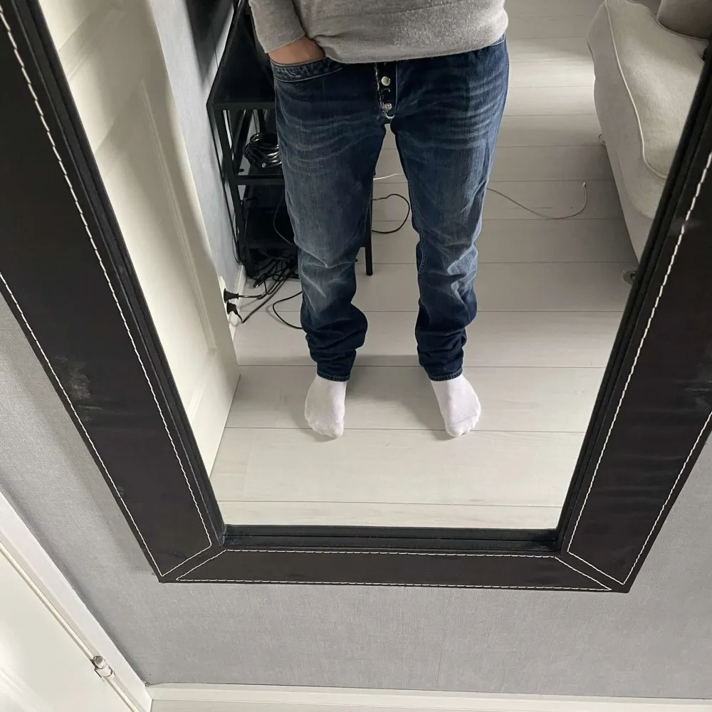 Säljer ett par snygga mörkblå jeans med knappar framtill. De har en klassisk straight fit och är perfekta för både vardag och fest. Jeansen är i bra skick och har en stilren design med fem fickor.30/32. Jeans & Byxor.