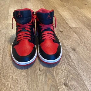 Nike Air Jordans i rött och svart - Säljer ett par snygga Nike Air Jordans i rött och svart. Skorna har en klassisk design med snörning och är i bra skick. Har några omärkbara defekter som man kan se på bild 4 och 5.Perfekta för både vardag och fest! Storlek herr 45. Passa på att köpa dessa ikoniska sneakers!