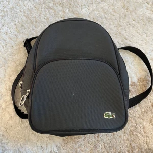 Lacoste ryggsäck  - En lite mindre Lacoste ryggsäck. Bra skick