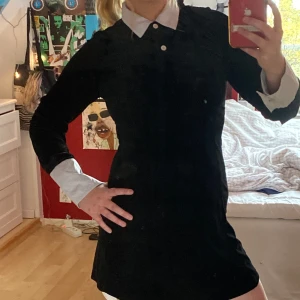 Svart sammetsklänning - En svart kort klänning i sammet med skjort- och knappdetaljer! Knappt använd. Perfekt om man till exempel ska klä ut sig till Wednesday Addams :) 