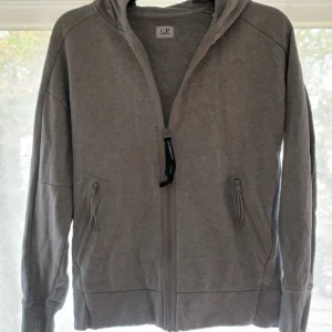 C.P Company Zip Hoodie - Stilren grå C.P company Zip Hoodie💫. Nypris 3200, skick 9/10 (Inga skador, enbart använd). Priset går att förhandla.