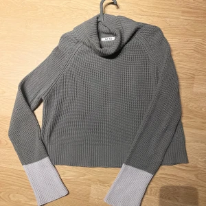 Grå stickad polotröja från NA-KD - Säljer en supermysig grå stickad polotröja från NA-KD. Den har en snygg kontrast med ljusare grå muddar och en skön polokrage. Perfekt för kyliga dagar och passar både till vardags och lite finare tillfällen. 🧶✨
