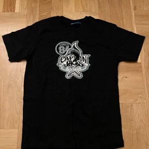 Svart T-shirt  - Snygg svart t-shirt med tryck på. Aldrig använd i super skick med strl M. 