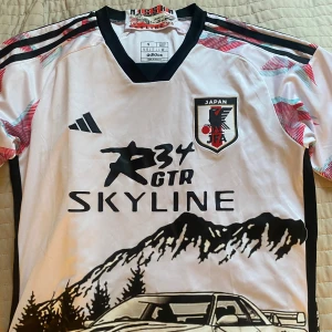 Designad fotbollströja  - Tryckt Japan fotbollströjan från en uk hemsida som designar fotbollströjor. Det står att det är adidas och har brodyr, men är inte säker på om den är äkta. Använt en gång kanske och är i bra skick. 