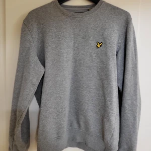 Collegetröja Lyle & Scott herr - Grå collegetröja i mycket bra skick från Lyle & Scott i strl. M.