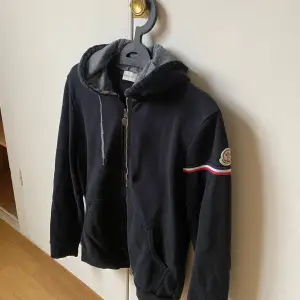 Mörkblå moncler ziphoodie, storlek M, skick 6/10 urtvättad men inga skador. Billigare går vid snabb och smidig affär. 