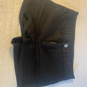 Svarta shorts med dragkedja - Säljer ett par svarta shorts i bra skick. De har en dragkedja och knapp framtill samt fickor bak. Perfekta för sommardagar eller en utekväll. Passar till det mesta och är superbekväma!
