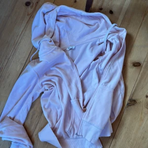 Ljusrosa hoodie - Mysig ljusrosa hoodie med dragkedja och huva.  Den har långa ärmar och en bekväm passform. Storlek s. 