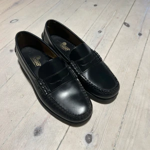 Sebago slip-ons - Sebago slip-ons loafers som är använda fåtal ggr. Tyvärr finns en liten repa, enbart den som syns på bild, annars är dem i superfint skick.   Nytt pris: 2999kr  Mitt pris: 1200kr