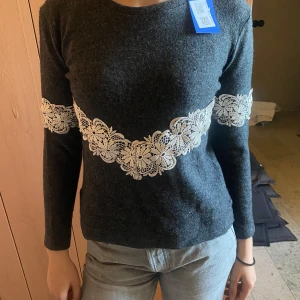 Grå tröja med spättsdetaljer  - Super gullig grå ulltröja med spättsdetalj. Köpt på selot för 150kr. Använd två tre gånger. Skriv om du har frågor