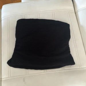 Svart ribbad kjol från Divided - Säljer en svart ribbad top från Divided. top är tight och perfekt för både vardag och fest. Den är i storlek S och har en elastisk passform som gör den bekväm att bära. Passar bra till en snygga jeans eller en kjol. Kan också användas som kjol🖤