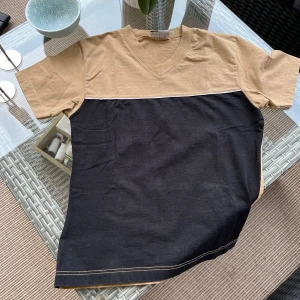 Söt t-shirt från Nelly - Säljer t-shirt i beige och svart från Nelly Collection. 95% bomull och 5% lyckra. Storlek M men känns som S. 
