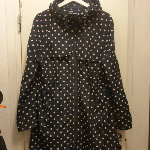 Prickig parkajacka från Denim Co. - Säljer en superfin parkajacka från Denim Co. i storlek S. Den är mörkblå med söta rosa prickar över hela. Jackan har en dragkedja framtill och praktiska fickor. Perfekt för vår och höst när vädret är lite ostadigt. Den har långa ärmar och en skön passform som gör den både snygg och bekväm.