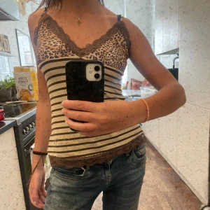 Leo topp - Jättefint linne med leo / randigt mönster med spetskanter. Där nere finns gulddetaljer (kan skicka närmre bilder) 💞💞 