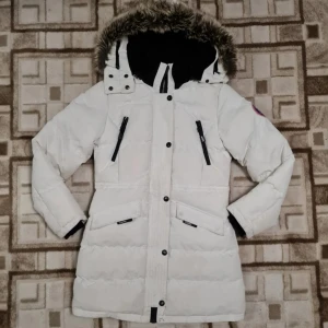 Vinterjacka (kappa) - Vit vinterjacka i storlek M, passar även bra för S storlekar. Finns resår på insidan av jackan för att tajta till på insidan av jackan. Dragkedjan är superenkelt att ta på och av. Håller dig rikgtigt varm på vintern när det är kallt. Snygg fluffig hu