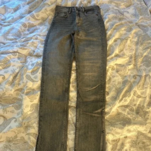 Grå jeans med fransade kanter - Säljer ett par grå jeans med slits, använda nån gång