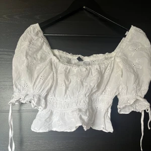 Topp - Kort topp med broderade blommor.