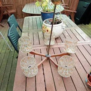 Vintage taklampa femarmad med trä,glas o mässing . Ena glas kupan fattas en liten flik .i övrigt hel lite fin jystering behövs.