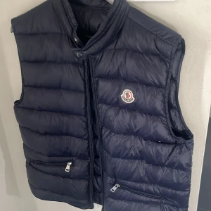 Moncler väst  - Säljer nu min moncler väst då den är för stor och inte kommer t användning Väldigt fint skick utan några defekter Skick 9/10 Storlek 2 = M 