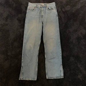 Blå jeans från Gina Tricot - Säljer ett par klassiska blå jeans från Gina Tricot Perfect Jeans i storlek 38. De har en straight passform. Bekväma och kan enkelt matchas med olika outfits. De har en knapp och dragkedja framtill och en slits längst ner på båda benen.