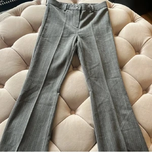 Kostymbyxor  - Gråa kostymbyxor från Ryvls. Lågmidjade, snygga och fina till alla årstider. Storlek xxs. Prisförslag accepteras.